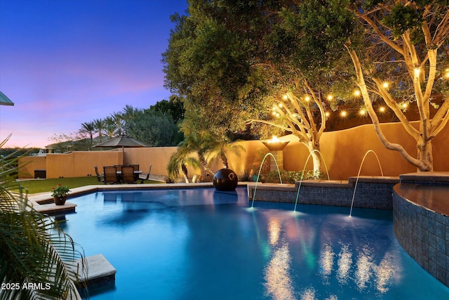 pool at dusk with pool water feature