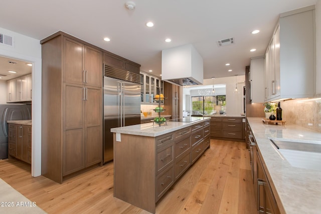 2737 E Arizona Biltmore Cir Unit 8, Phoenix, AZ 85016 - kitchen featuring built in refrigerator, a kitchen island, light wood-style flooring, glass insert cabinets, and recessed lighting