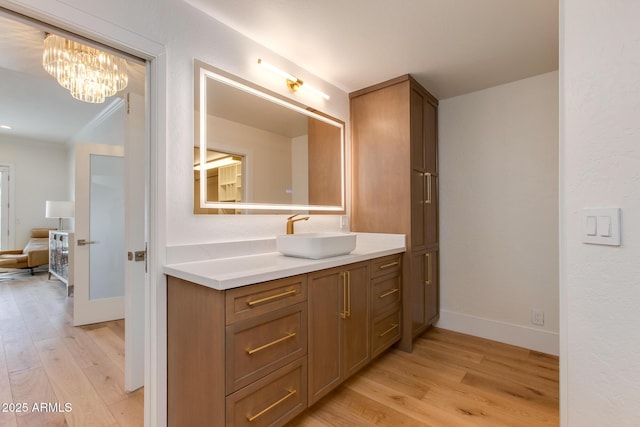 2737 E Arizona Biltmore Cir Unit 8, Phoenix, AZ 85016 - bathroom with wood finished floors, vanity, baseboards, a chandelier, and crown molding
