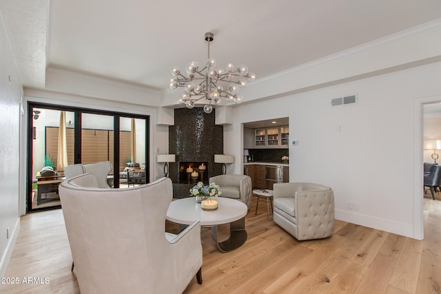 2737 E Arizona Biltmore Cir Unit 8, Phoenix, AZ 85016 - dining area featuring baseboards, crown molding, light wood finished floors, a chandelier, and a premium fireplace