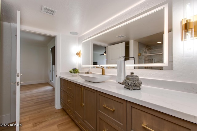 2737 E Arizona Biltmore Cir Unit 8, Phoenix, AZ 85016 - bathroom featuring wood finished floors, vanity, baseboards, and a shower