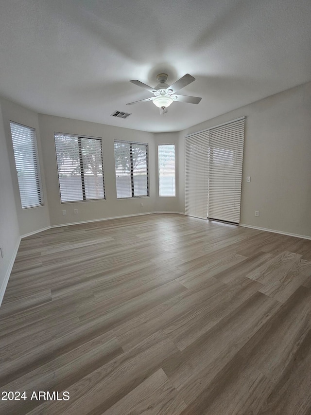 spare room with ceiling fan, hardwood / wood-style flooring, and a textured ceiling