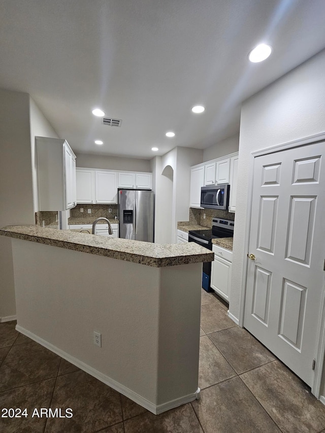 kitchen featuring tasteful backsplash, stainless steel appliances, and white cabinets