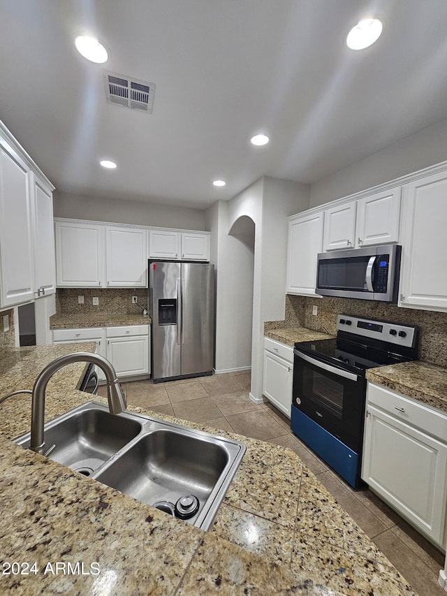 kitchen featuring white cabinets, backsplash, and stainless steel appliances