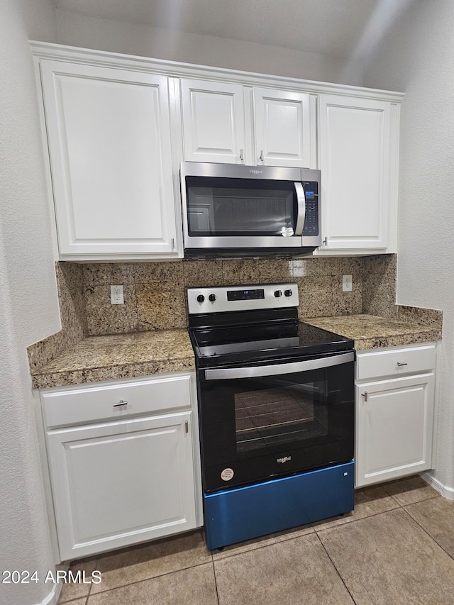 kitchen with appliances with stainless steel finishes, white cabinetry, and backsplash