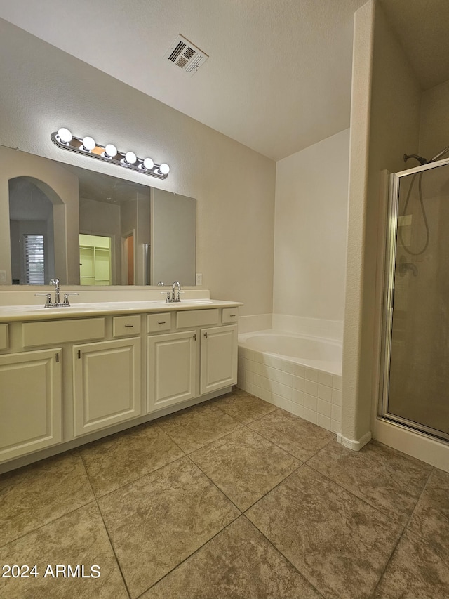 bathroom with vanity, a textured ceiling, separate shower and tub, and tile patterned flooring