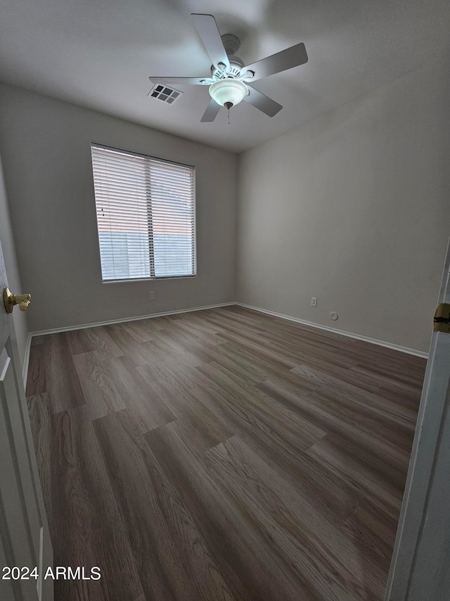 empty room featuring ceiling fan and dark hardwood / wood-style flooring