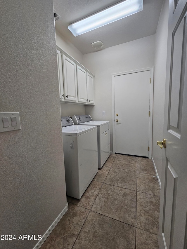 laundry room featuring cabinets, independent washer and dryer, and tile patterned flooring