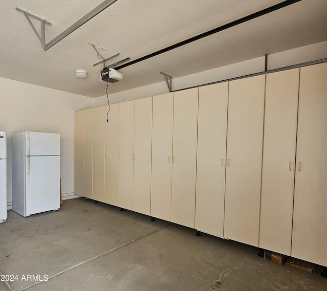 garage with a garage door opener and white fridge