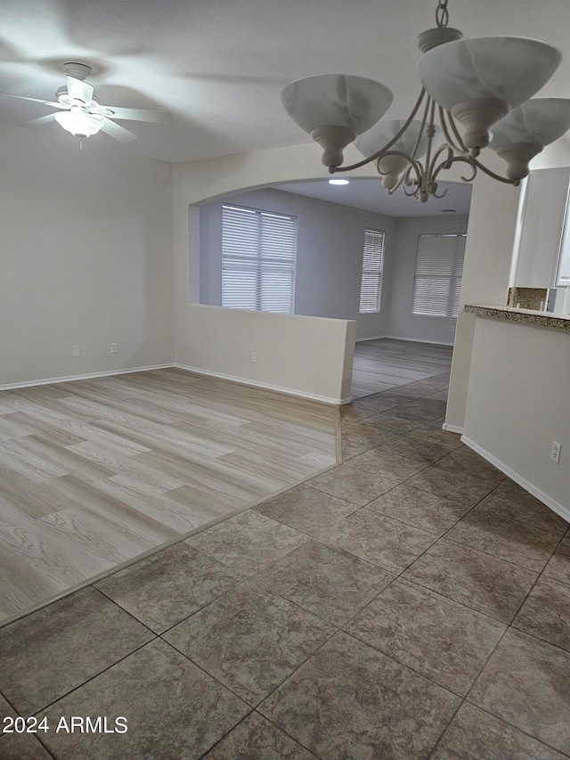 empty room featuring hardwood / wood-style floors and ceiling fan with notable chandelier