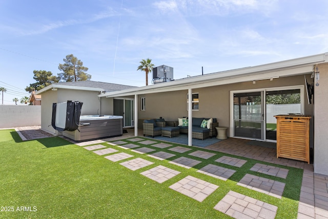 back of house featuring a hot tub, a patio area, stucco siding, fence private yard, and outdoor lounge area