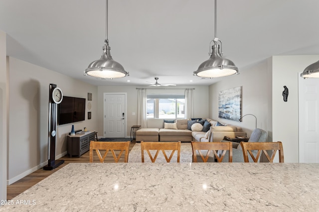 dining room with wood finished floors, baseboards, and ceiling fan
