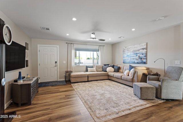 living room featuring a ceiling fan, recessed lighting, visible vents, and wood finished floors