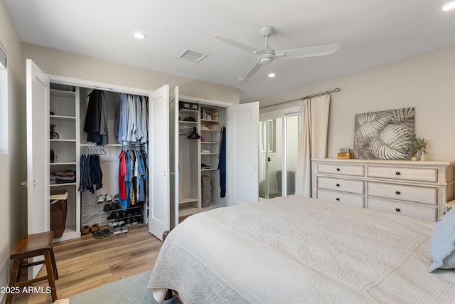 bedroom with wood finished floors, a ceiling fan, two closets, visible vents, and recessed lighting
