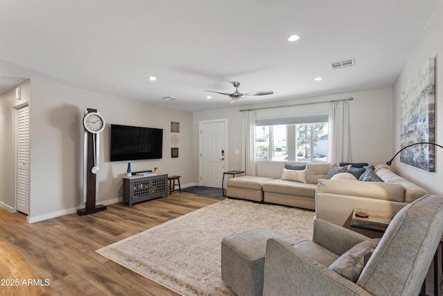 living room featuring recessed lighting, baseboards, visible vents, and wood finished floors