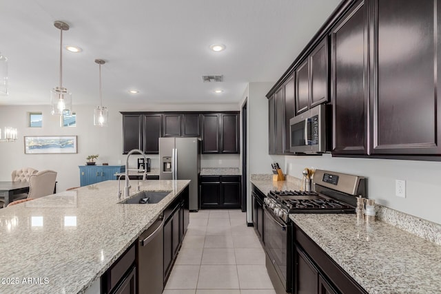 15276 W Latham St, Goodyear, AZ 85338 - kitchen with stainless steel appliances, light tile patterned floors, light stone countertops, decorative light fixtures, and recessed lighting