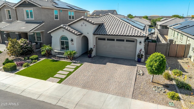 15276 W Latham St, Goodyear, AZ 85338 - view of front of home with stucco siding, an attached garage, a tile roof, decorative driveway, and a residential view