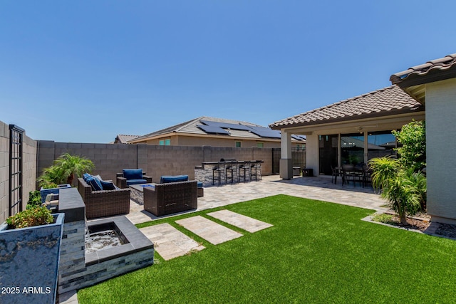 15276 W Latham St, Goodyear, AZ 85338 - fenced backyard featuring a patio area and an outdoor living space with a fire pit
