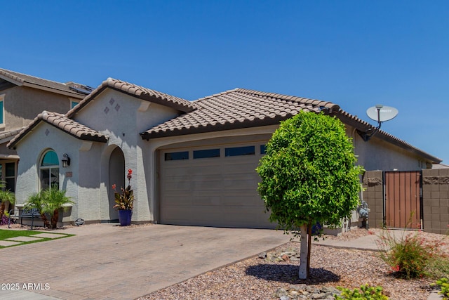 15276 W Latham St, Goodyear, AZ 85338 - view of front facade featuring an attached garage, driveway, a gate, a tile roof, and stucco siding