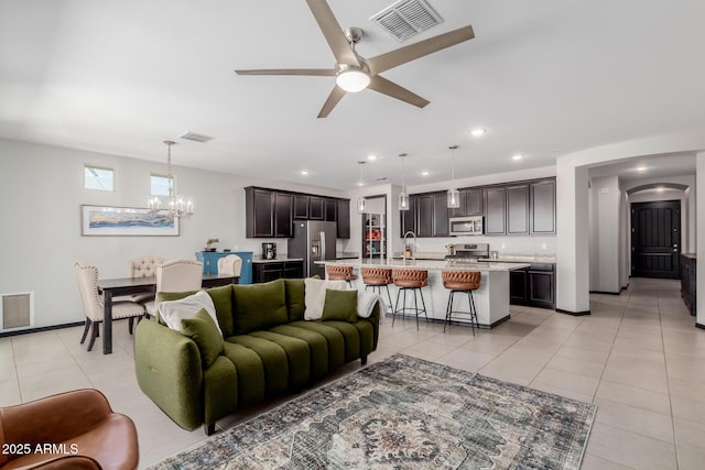 15276 W Latham St, Goodyear, AZ 85338 - living room with a chandelier, arched walkways, light tile patterned flooring, ceiling fan, and recessed lighting