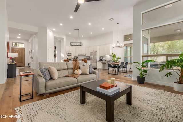 living room with a chandelier and light hardwood / wood-style flooring