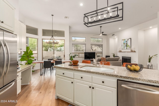 kitchen featuring white cabinets, appliances with stainless steel finishes, plenty of natural light, and light hardwood / wood-style floors