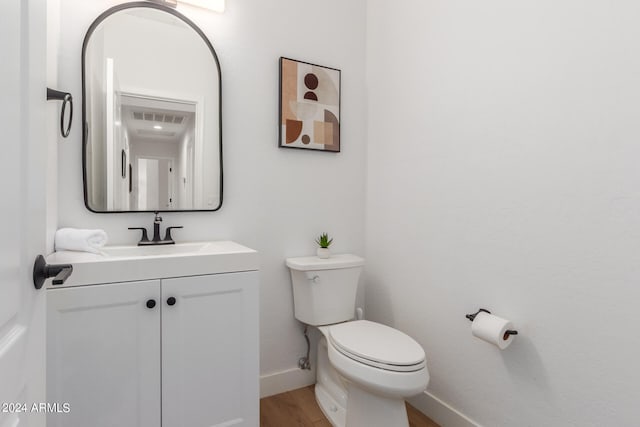 bathroom with vanity, hardwood / wood-style floors, and toilet