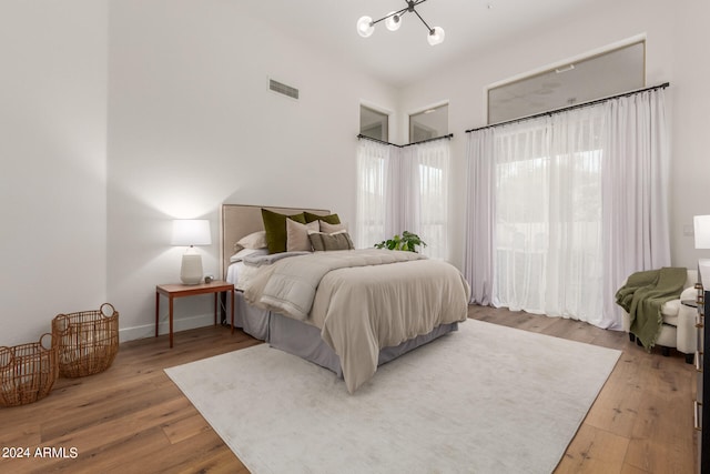 bedroom featuring hardwood / wood-style flooring and a notable chandelier