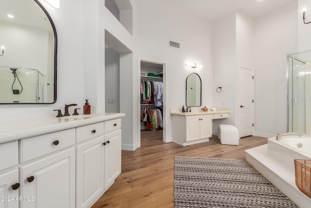 bathroom featuring wood-type flooring, vanity, and independent shower and bath