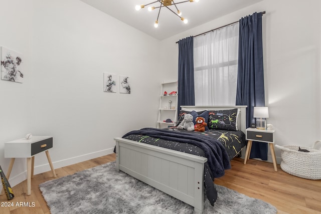 bedroom featuring wood-type flooring and a chandelier