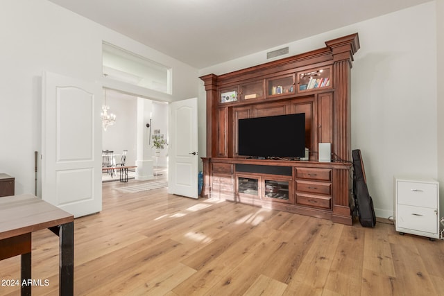 living room with a notable chandelier and light wood-type flooring