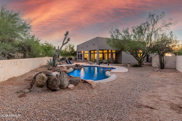 pool at dusk featuring a patio area