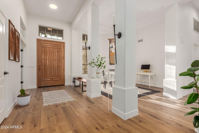 entrance foyer featuring light wood-type flooring and a towering ceiling