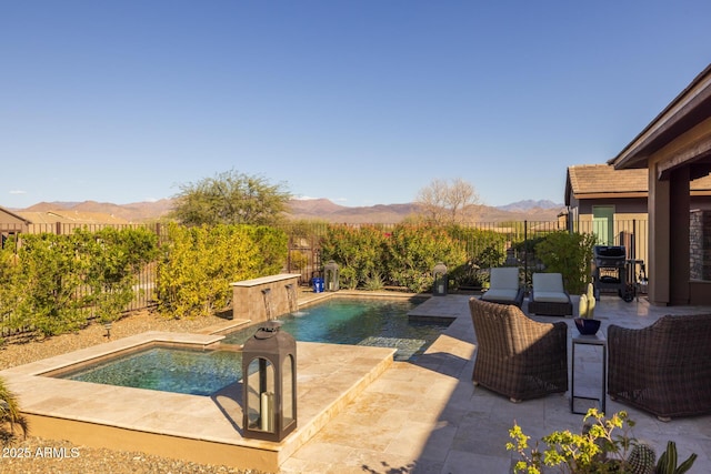 view of pool with a patio area, a hot tub, a mountain view, and a fenced backyard