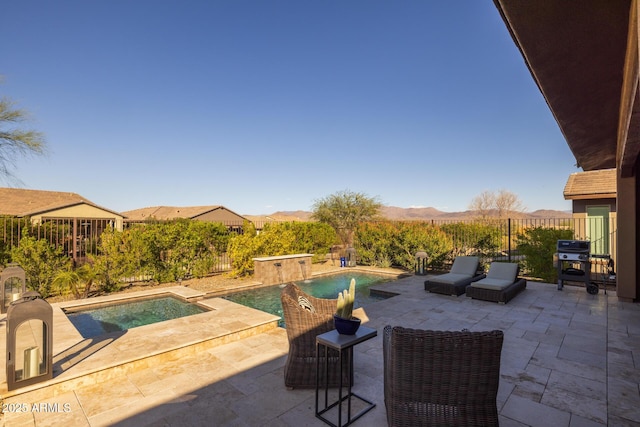 view of patio featuring a mountain view, an in ground hot tub, a fenced backyard, and a fenced in pool