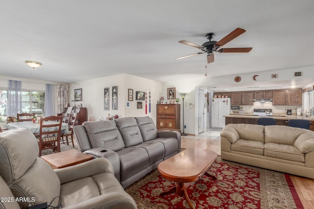 living room with ceiling fan and light hardwood / wood-style flooring