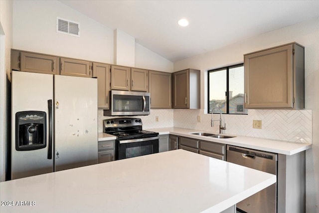 kitchen with stainless steel appliances, lofted ceiling, sink, and backsplash