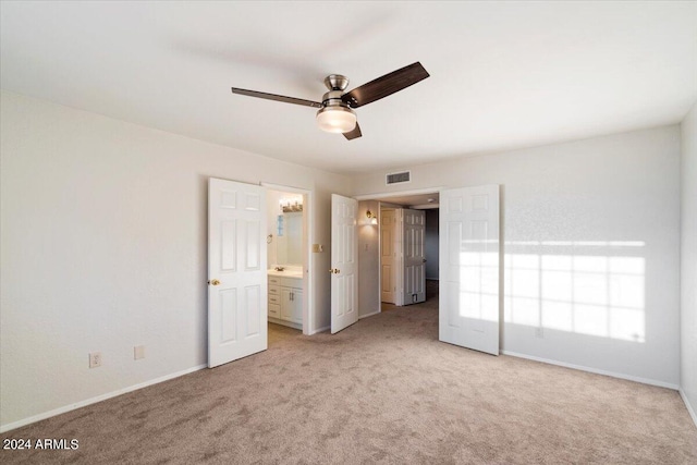 unfurnished bedroom featuring ceiling fan, connected bathroom, and light carpet