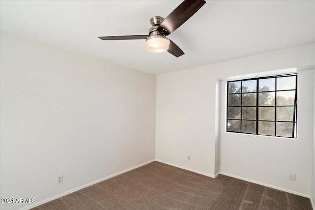 unfurnished room featuring ceiling fan and dark carpet