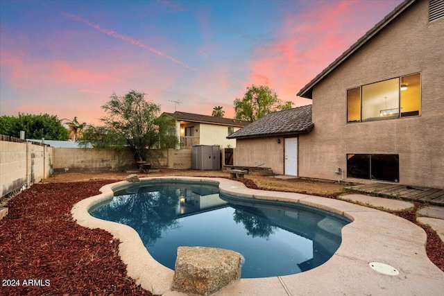 pool at dusk with a patio area