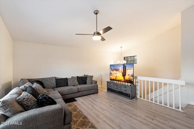 living room featuring ceiling fan with notable chandelier, lofted ceiling, and hardwood / wood-style flooring