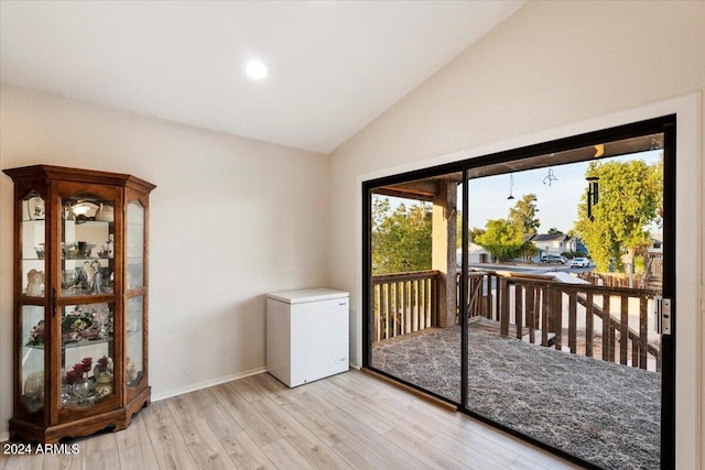 doorway featuring light hardwood / wood-style floors and vaulted ceiling