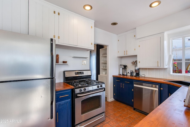 kitchen featuring a sink, blue cabinetry, stainless steel appliances, and butcher block counters