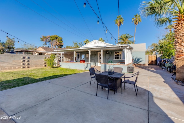 view of patio with a gate, outdoor dining area, and fence