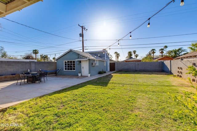 view of yard featuring a patio area, a fenced backyard, and an outbuilding