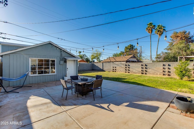 view of patio / terrace with an outbuilding, outdoor dining area, and a fenced backyard