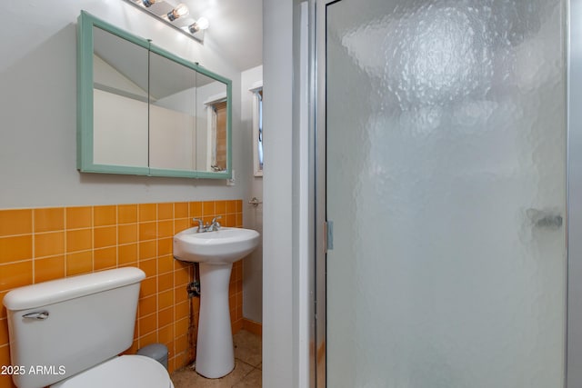 full bathroom featuring tile patterned floors, tile walls, and a stall shower