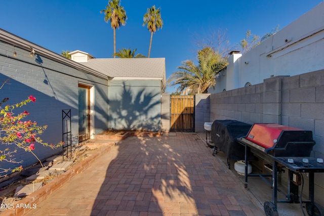 view of patio / terrace featuring fence, a grill, and a gate