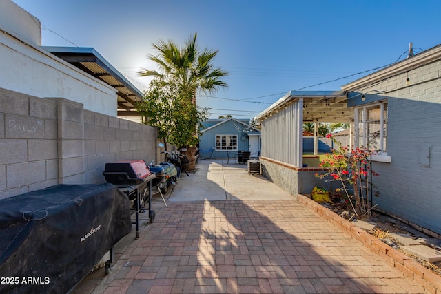 view of patio / terrace with area for grilling, an outdoor structure, and fence