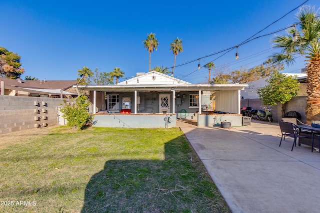 rear view of property featuring a patio area, fence, and a lawn